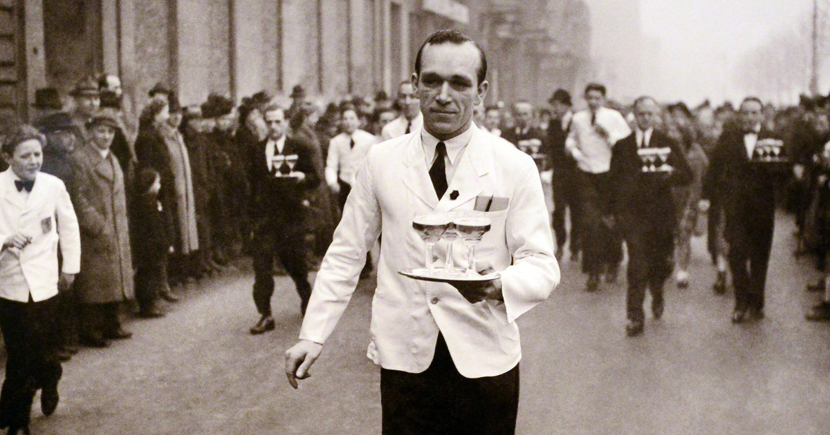 Historisches Foto zeigt mehrere Kellner mit Tablett bei einem Wettlauf auf der Kö