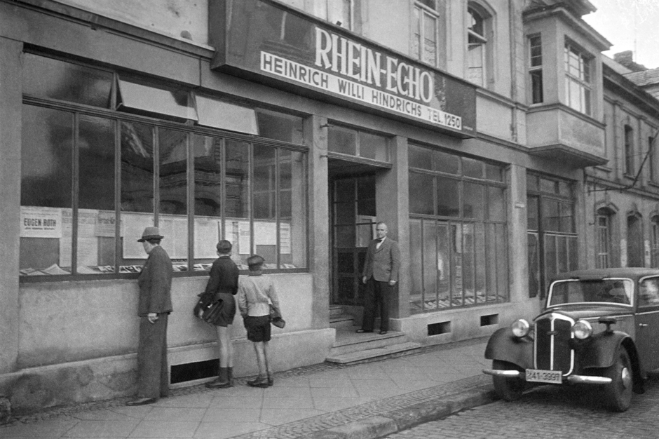 Menschen stehen vor dem Fenster der Geschäftsstelle