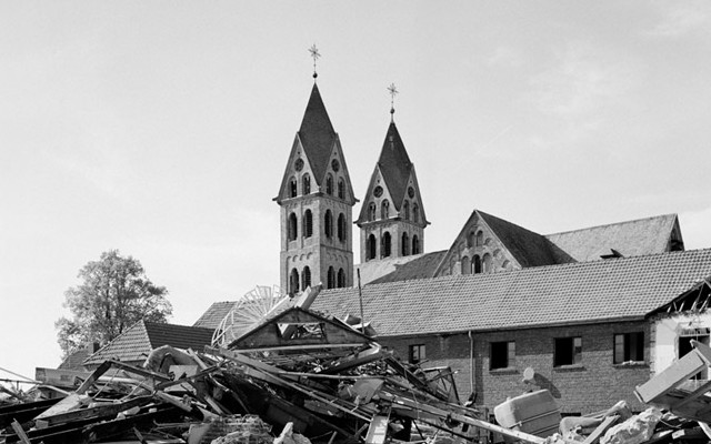 Überreste eines Hauses mit Kirchtürmen im Hintergrund