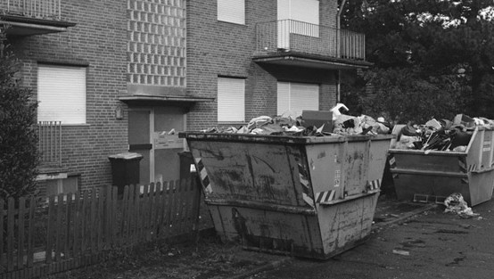 Vor einem Haus steht ein Container