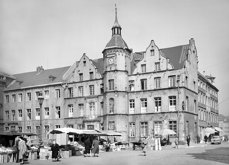 Außenansicht eines Gebäudes mit Marktständen im Vordergrund.