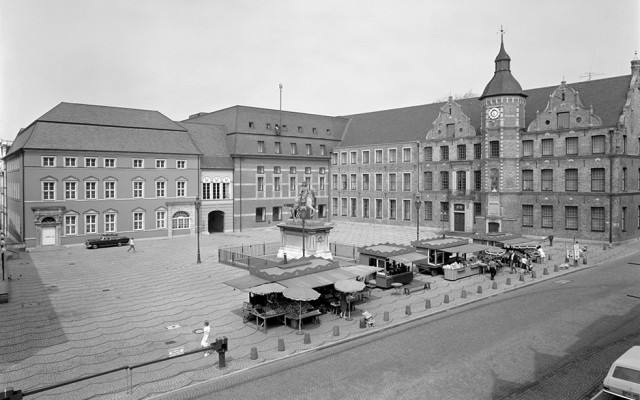 Ein Platz mit Marktständen und mehreren Gebäuden.