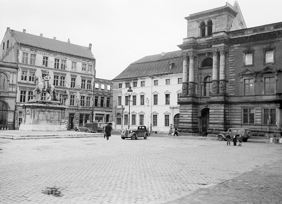 Ein Platz mit einem Denkmal und mit mehreren Gebäuden.