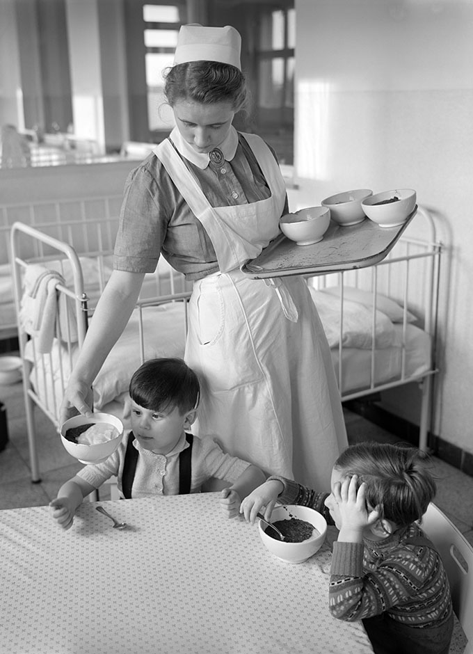 LVR-ZMB, K.-H. Hahn Eine Frau verteilt Teller mit Essen.