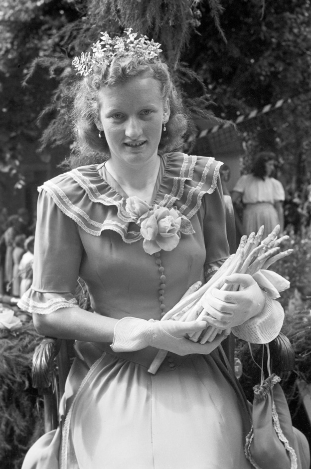 Eine Frau trägt Spargelstangen.