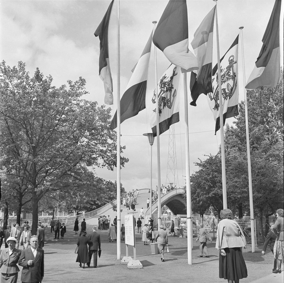 LVR-ZMB, B. Müller-Schwanneke Fahnenmaste mit einer Brücke im Hintergrund.