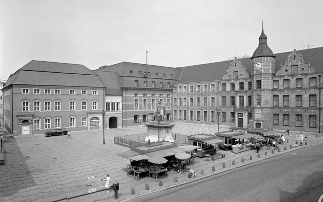 Ein Platz mit Marktständen und mehreren Gebäuden.