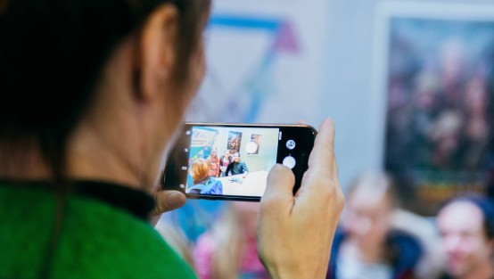 Frau mit Handy fotografiert Checker Tobi bei Autogrammstunde