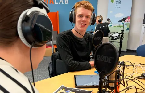 Schüler*innen vor Podcast-Mikrofon