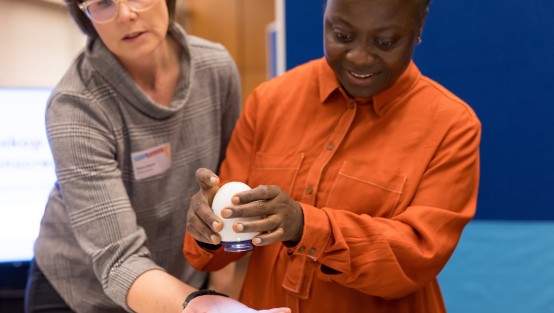 Kita-Fachkraft und Medientrainerin probieren ein Kinder-Mikroskop aus.