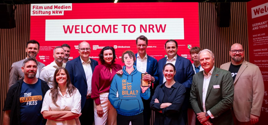 Foto: Film- und Medien Stiftung NRW gruppenfoto Politiker mit der Figur aus dem Spiel " Wer ist Bilal?"