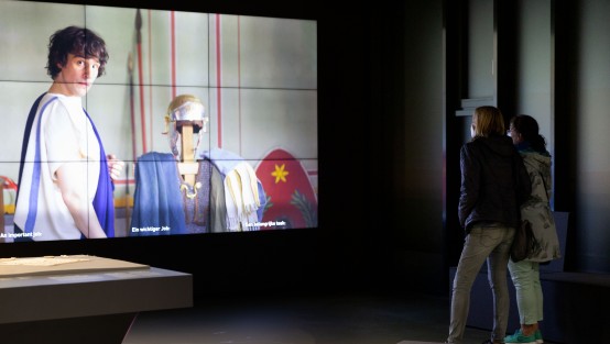 Videowand mit Besuchern der Eröffnung der Landesausstellung Limes