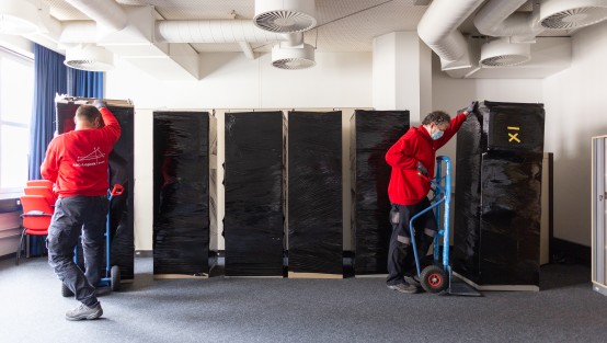 Zwei Personen transportieren verpackte Möbel 