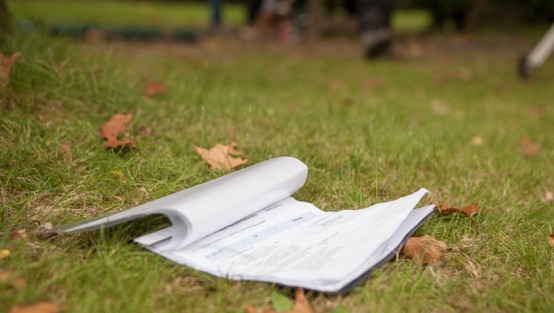 Ein offenes Heft liegt auf dem Rasen des ehemaligen Anstaltsfriedhofs.