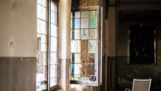 Kaputtes Fenster in einem heruntergekommenen Gebäude.