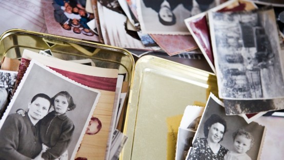 Offene Blechdose mit alten Schwarzweiss- und Farbfotos