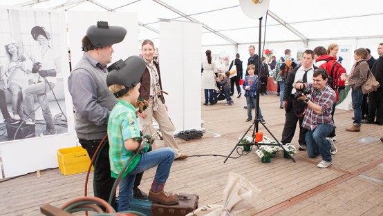 Foto: Julia Reschucha/LVR-ZMB, 2013 Fotograf fotografiert einen Mann und einen Jungen in einem kleinen Set