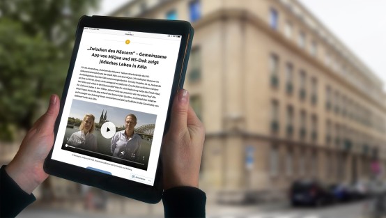 IPad zeigt den Blogeintrag von MiQua vor dem NS-Dokumentationszentrum.