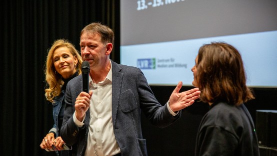 LVR-Direktorin Ulrike Lubek, Stadtdirektor Burkhard Hintzsche und Leiterin des KiKiFes Franziska Ferdinand beim Familiensamstag Foto: © Hannah Heimbuchner I LVR-ZMB Menschen vor einer Kinoleinwand.